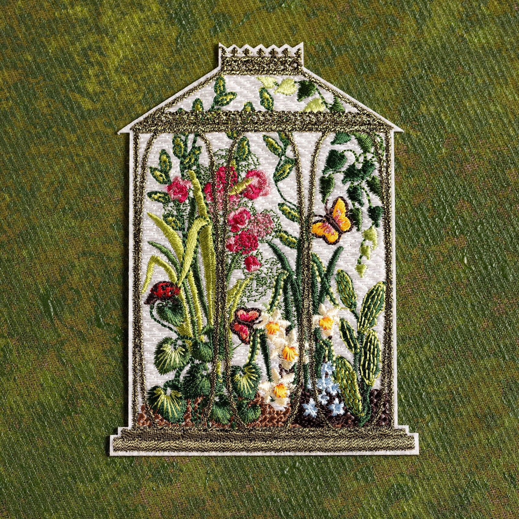 Locks Greenhouse Embroidered Patch - Embroidered patch of a greenhouse with flowers and plants on a green fabric background