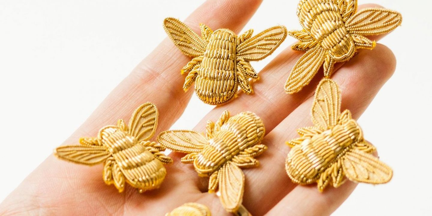 Golden bees spread on fingers
