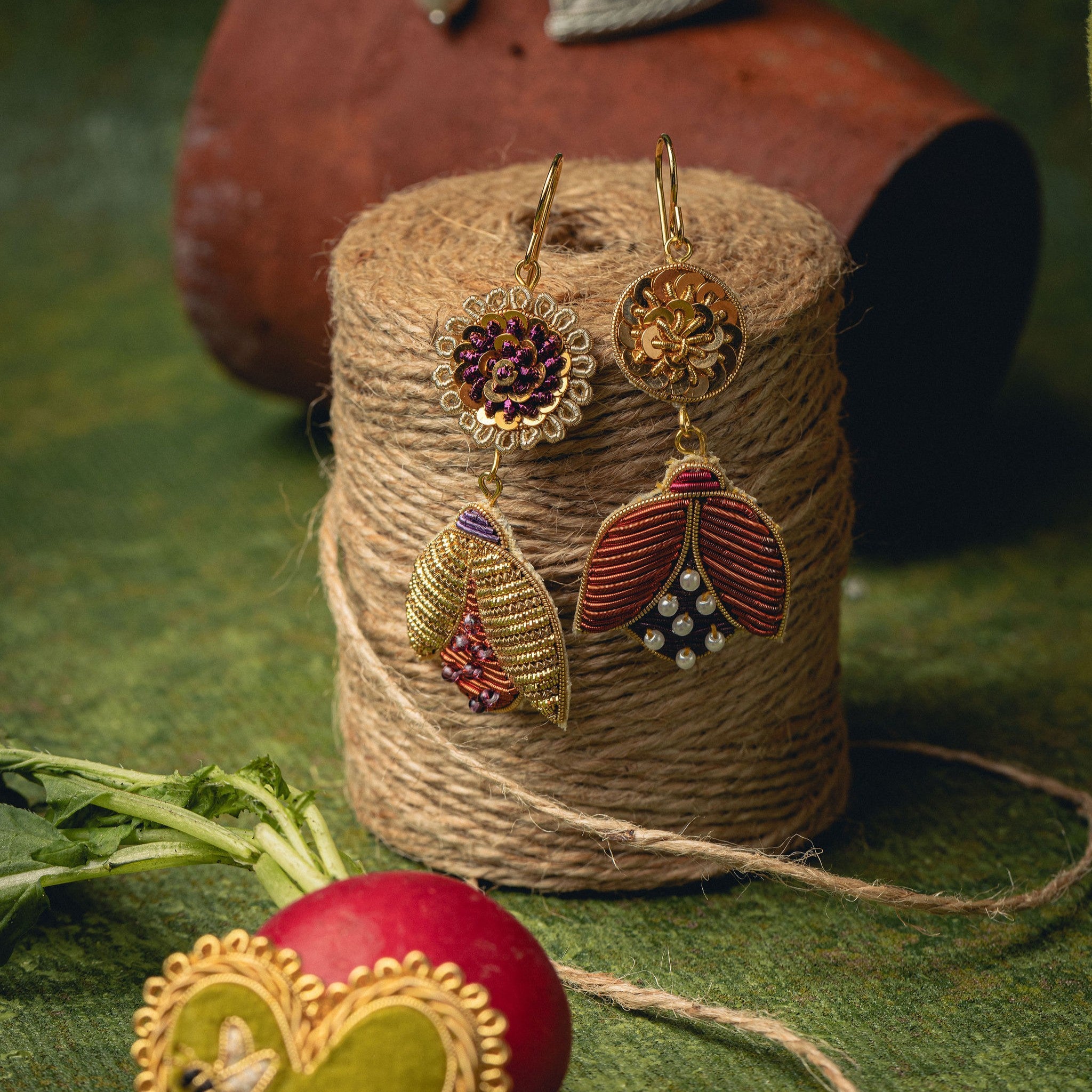 Beetle Earrings - Hand Embroidered beetle earrings hanging off a spool of twine