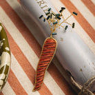 Carrot Brooch - Hand Embroidered carrot brooch on a striped background