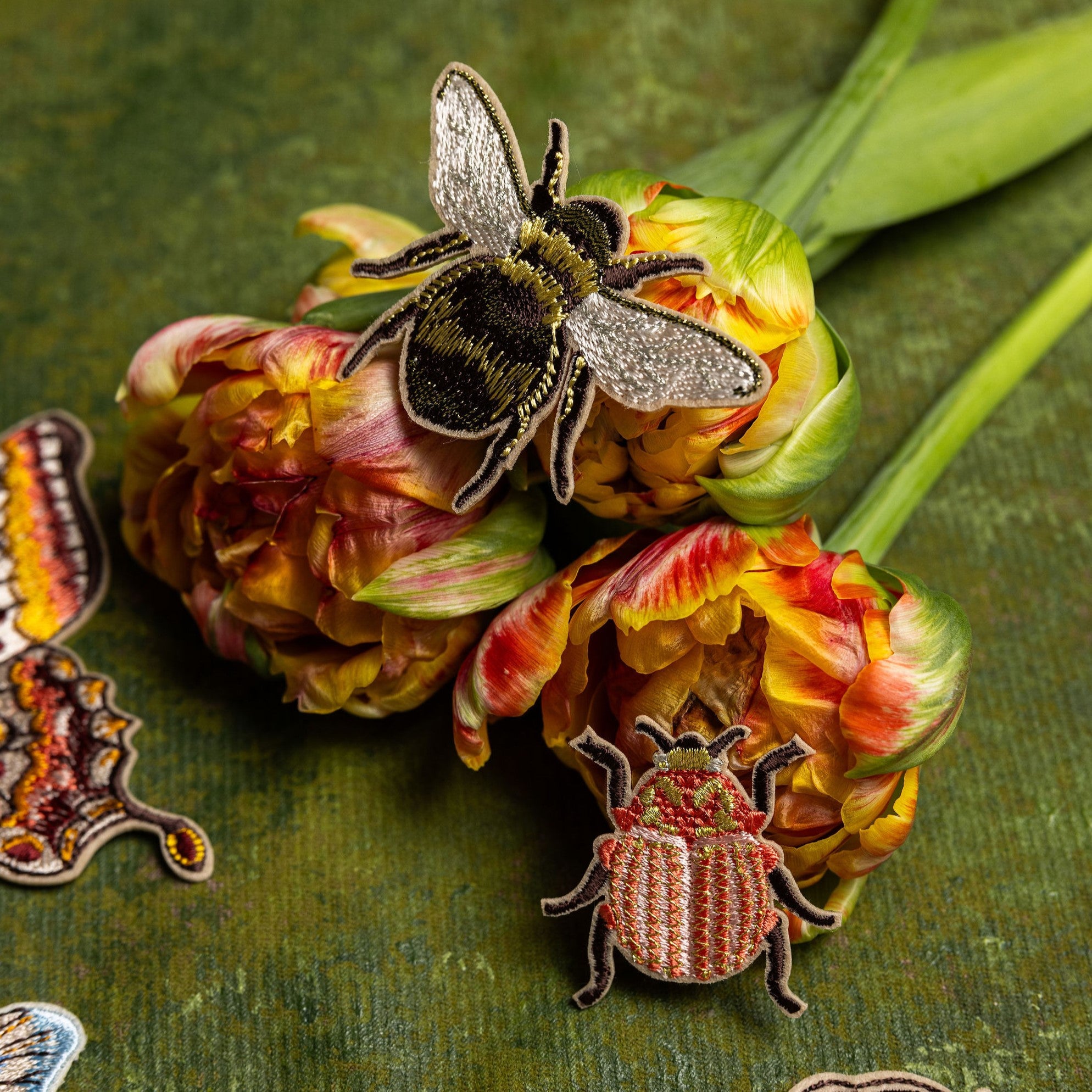Garden Insects Embroidered Patch Set - Bee and Beetle embroidered patches on a bouquet of flowers with a green background