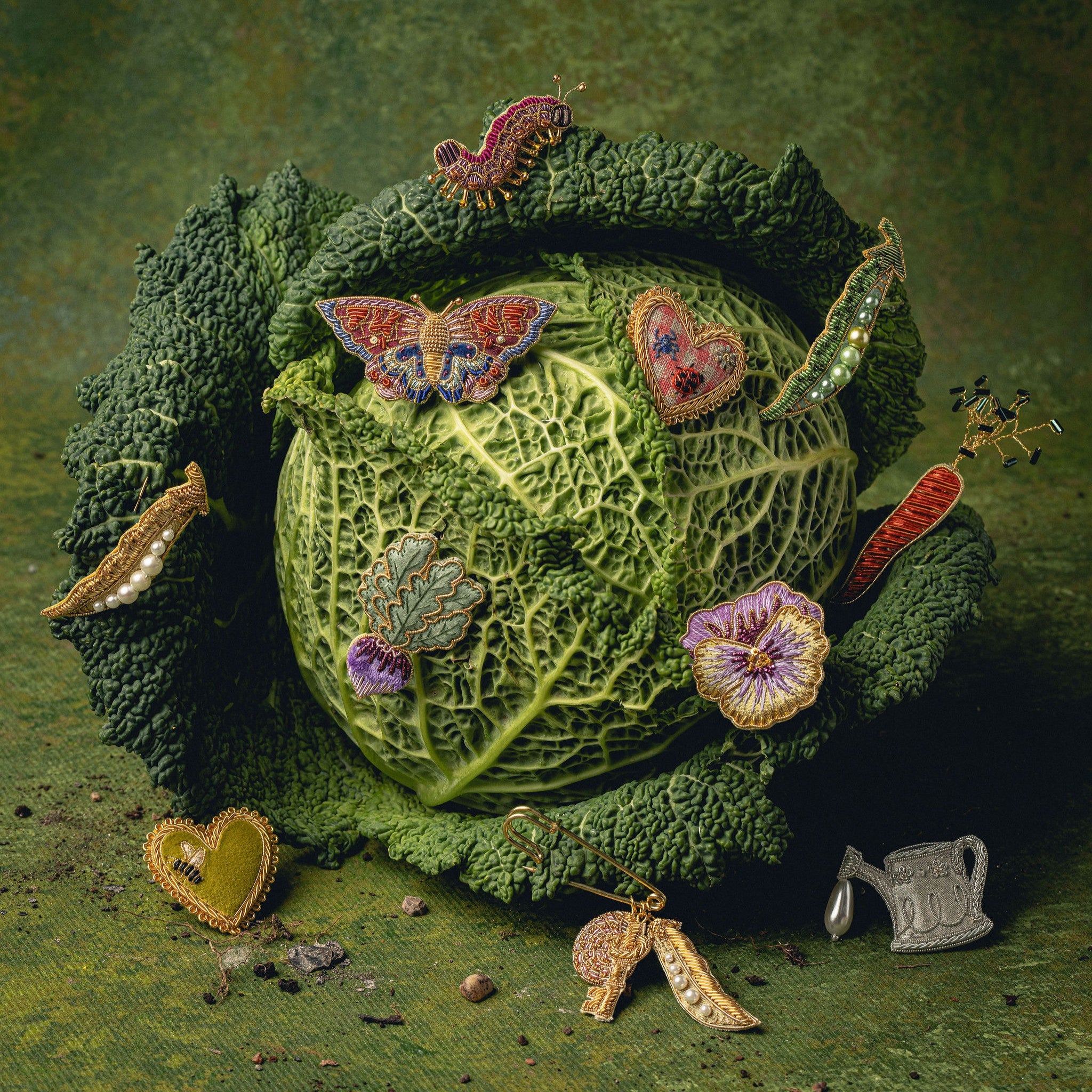 How Does Your Garden Grow? Collection of Hand Embroidered Jewellery - Decorative brooches on a cabbage against a green background