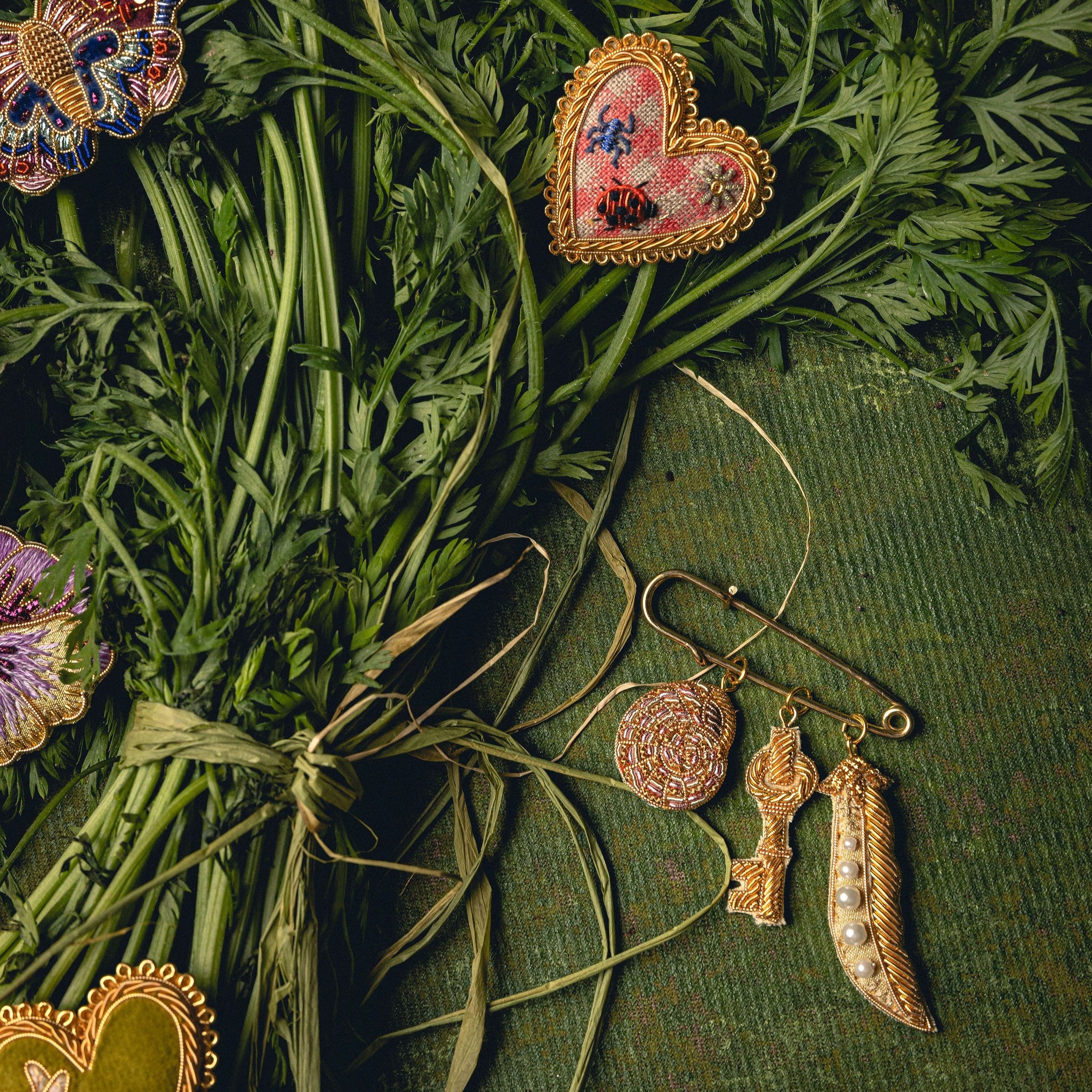 How Does Your Garden Grow? Collection of Hand Embroidered Jewellery - Hand embroidered brooches photographed on leaves and green background