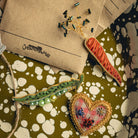 How Does Your Garden Grow? Collection of Hand Embroidered Jewellery - Decorative brooches on a patterned green and white tray