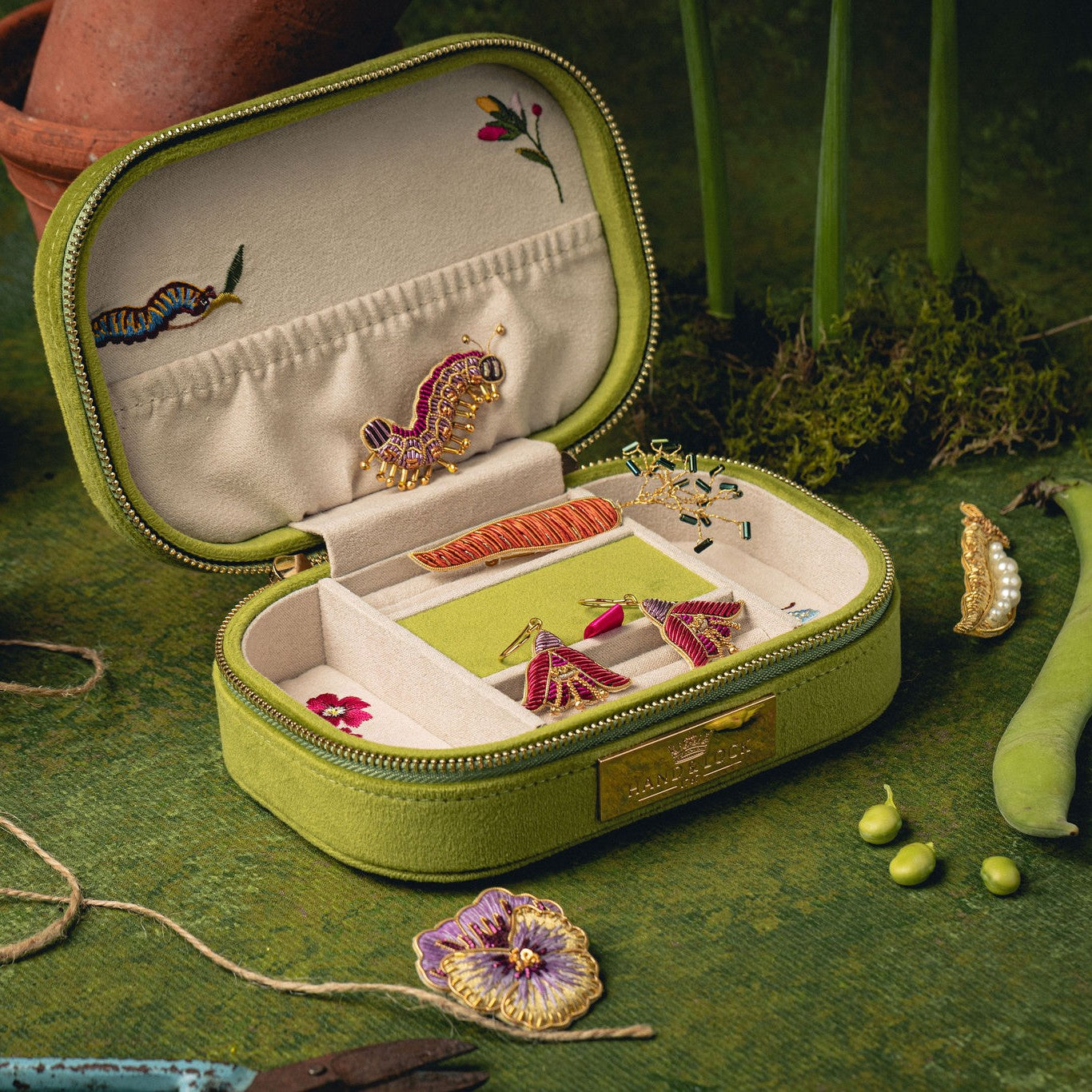 How Does Your Garden Grow? Collection of Hand Embroidered Jewellery - embroidered jewellery shown in our green embroidery case on a green background 