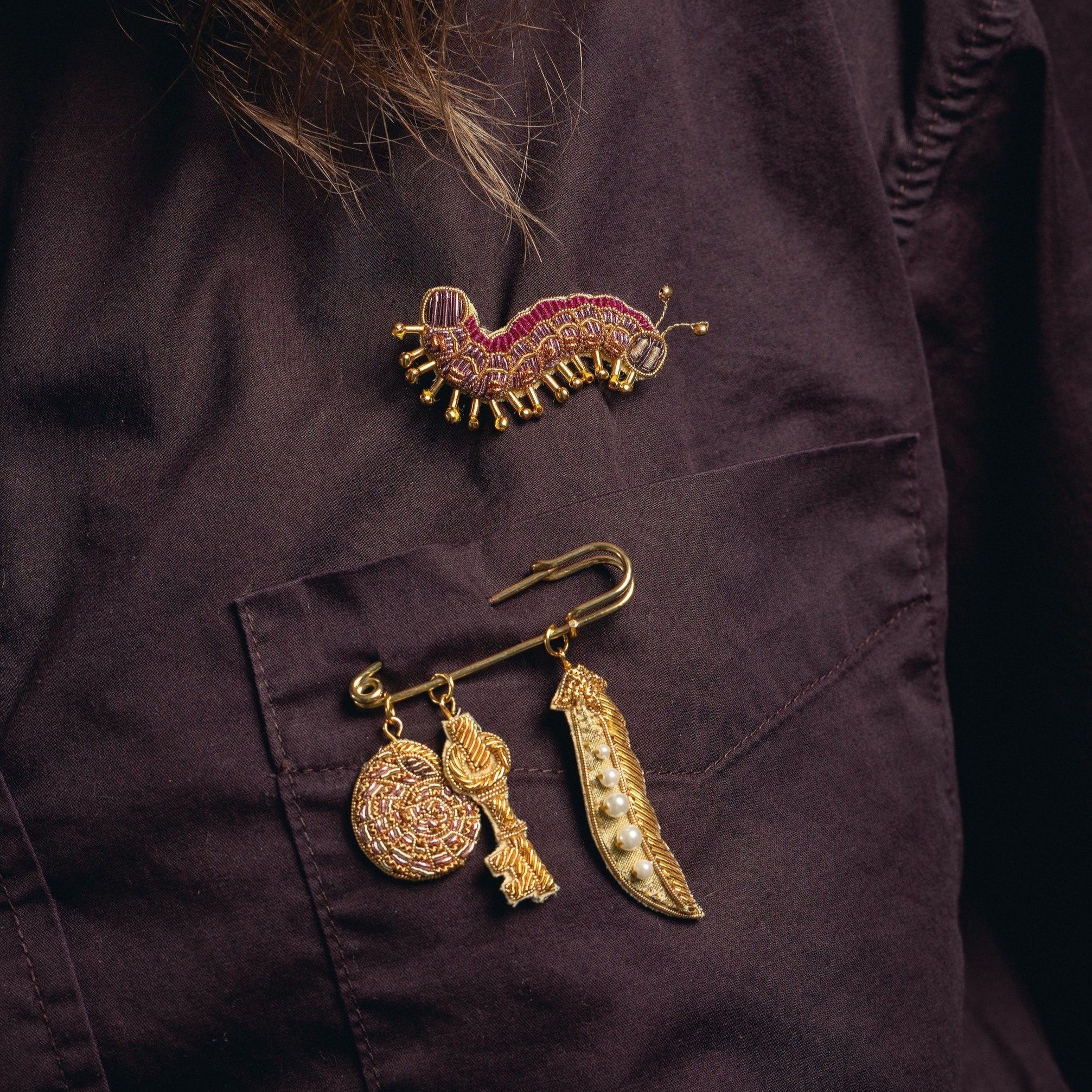 How Does Your Garden Grow? Collection of Hand Embroidered Jewellery - Decorative brooches displayed on a purple shirt