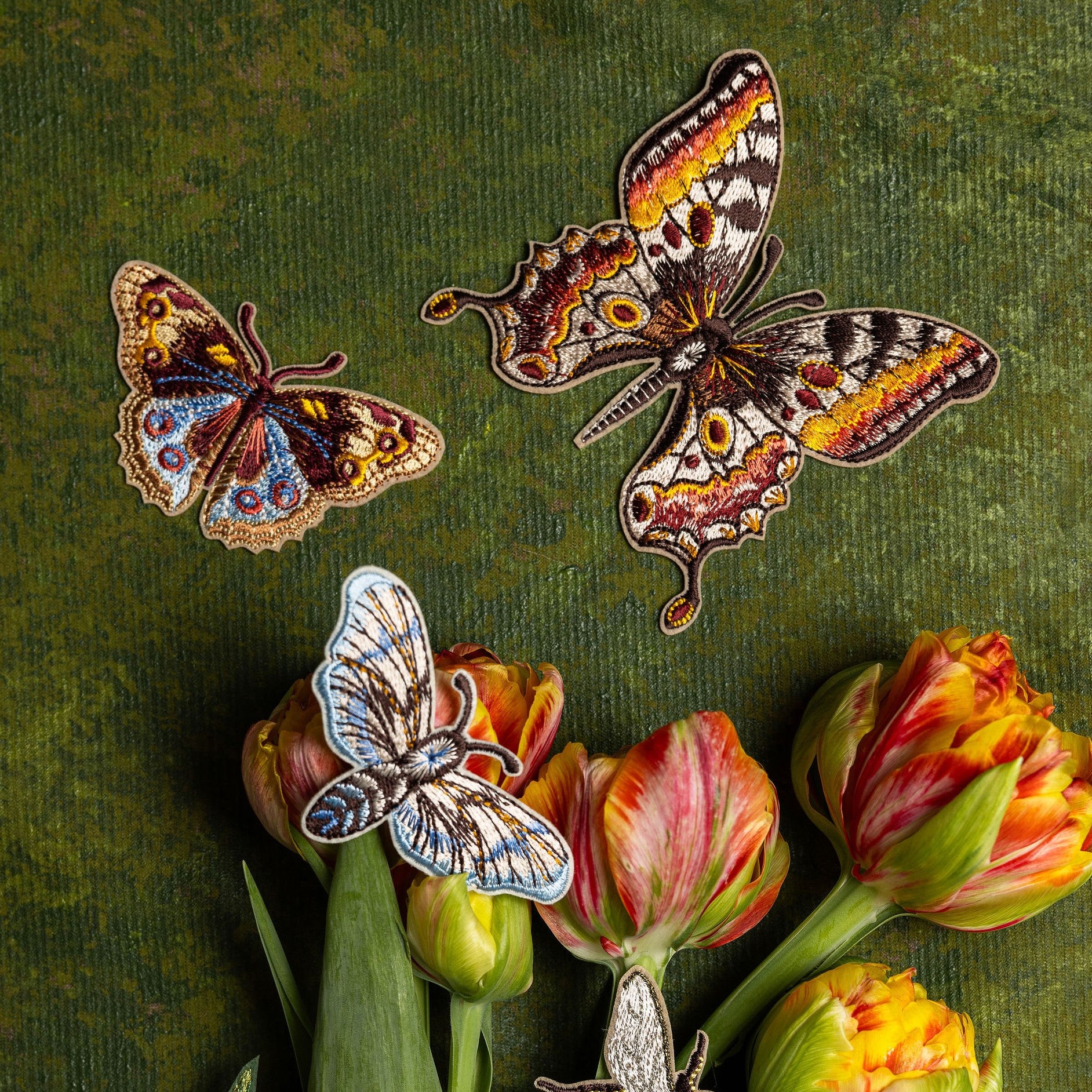 Kaleidoscope Butterflies Embroidered Patch Set - Butterfly-themed patches on a green background with tulips.