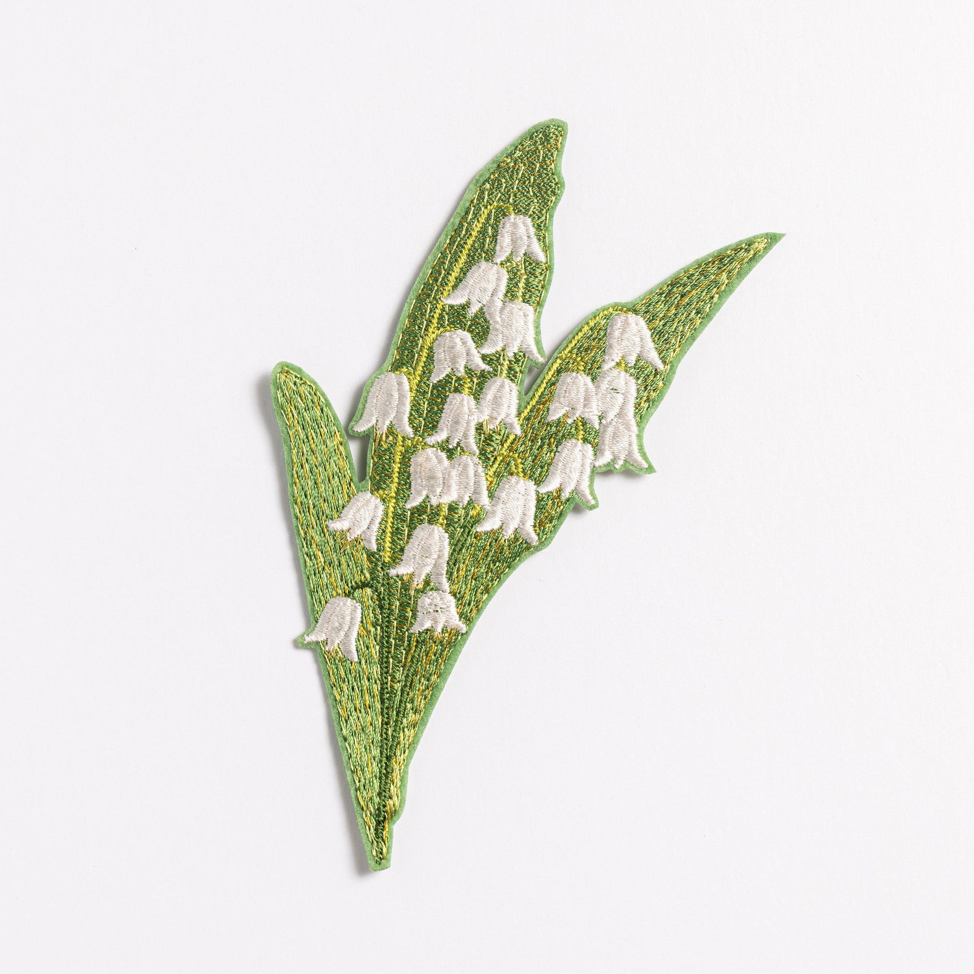 Lily of the Valley Flower Embroidered Patch - Embroidered patch of lily of the valley flowers on a green leafy background