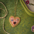 Picnic Heart Necklace - Hand Embroidered necklace shown on a green background 