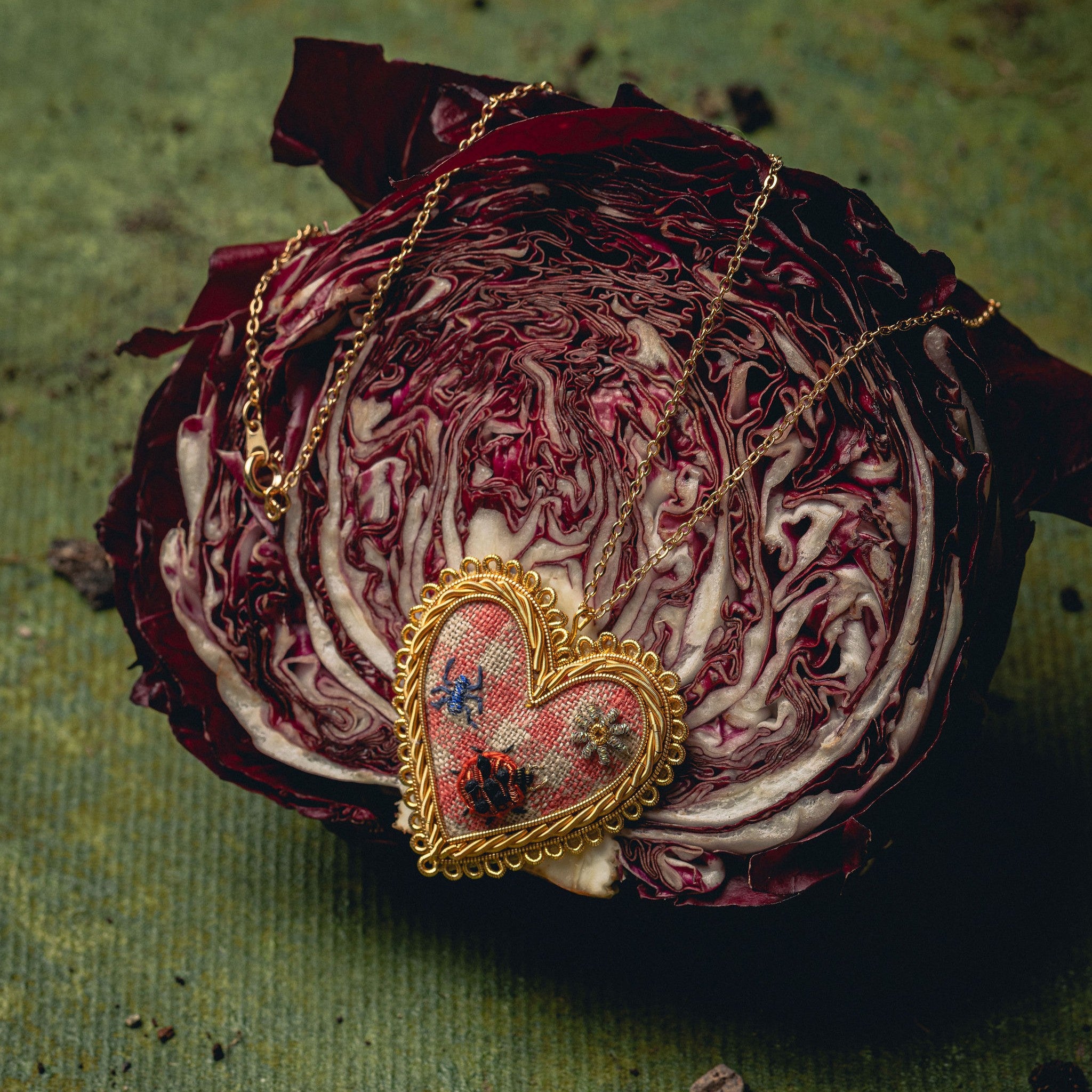 Picnic Heart Necklace - Hand Embroidered necklace draped over a red cabbage