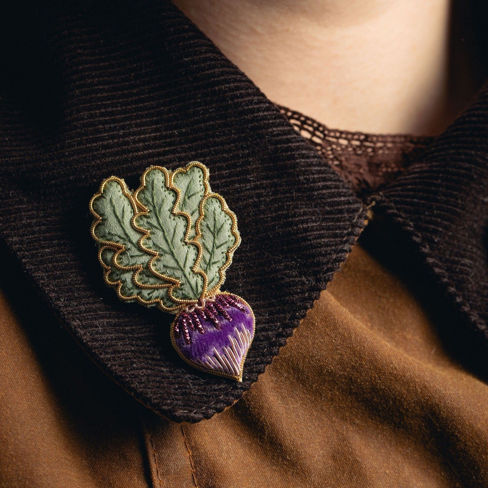 Radish brooch worn on a dark jacket collar