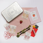 The Strawberry Kit - Strawberry embroidery kit with materials on a white background