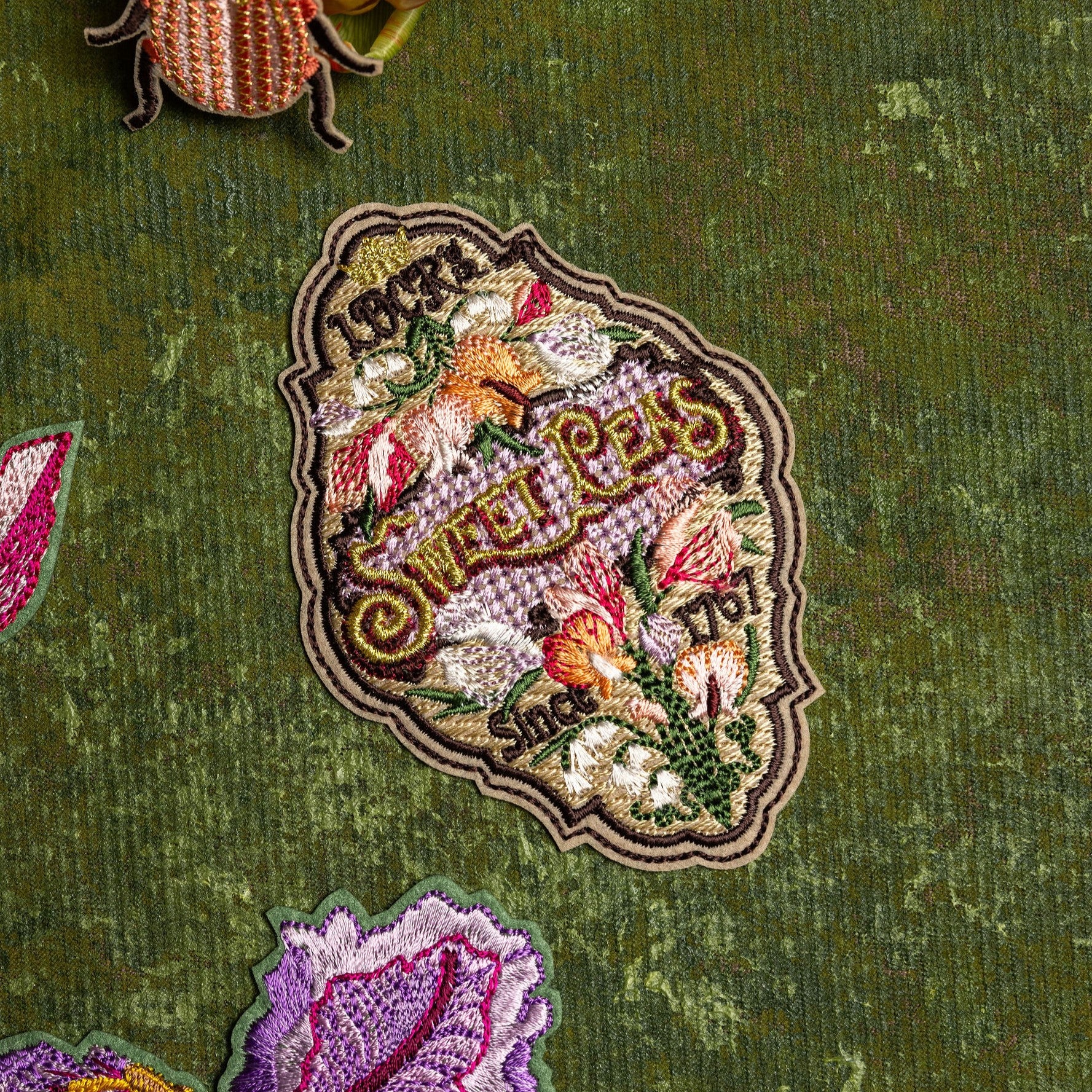 Sweet Pea Seeds Patch - Decorative patch of a sweet pea seed label on a green background