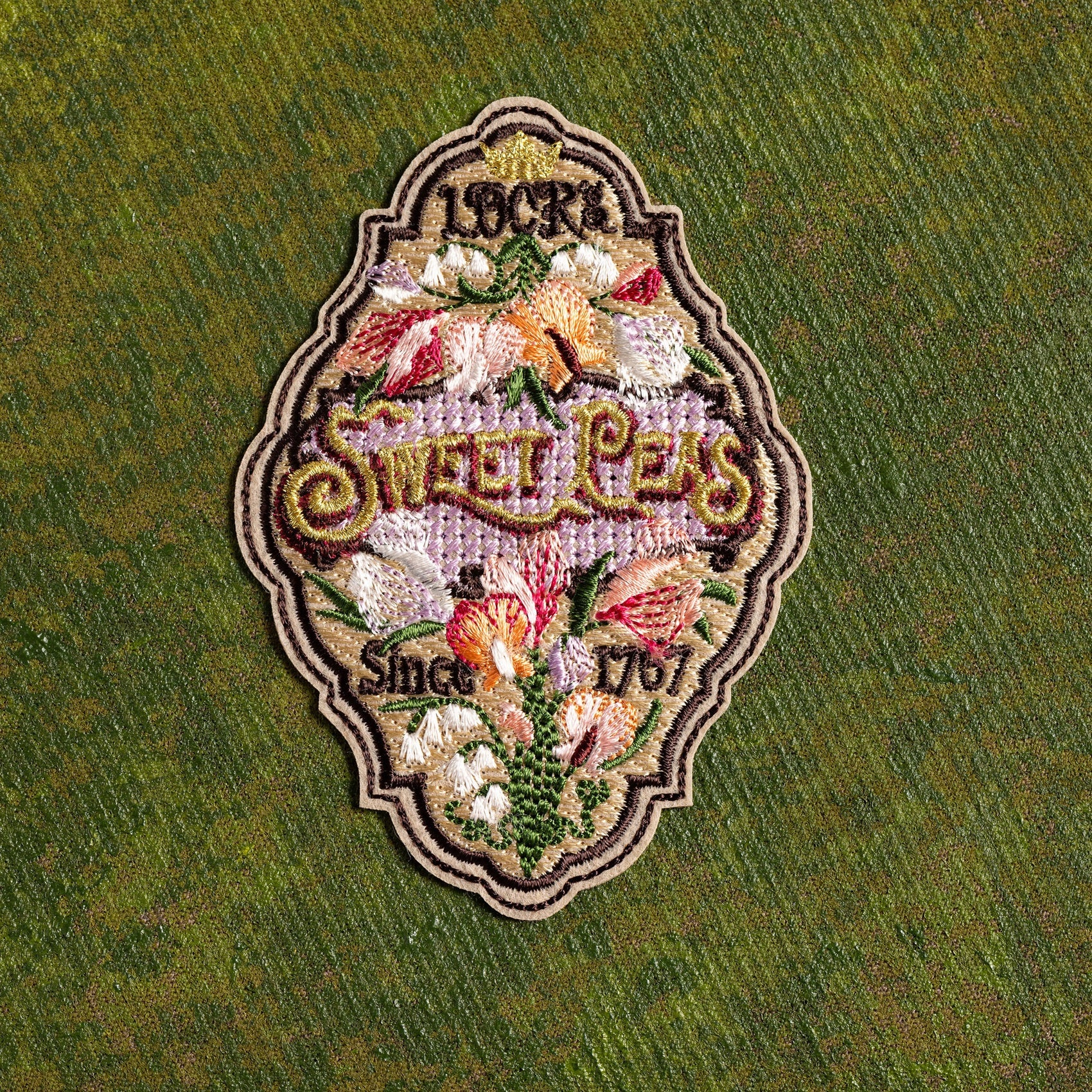 Sweet Pea Seeds Patch - Decorative patch of a sweet pea seed label on a green background