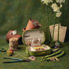 The Garden Embroidered Jewellery Box - Embroidered Jewellery Box displaying an array of embroidered jewellery, on a green background with flowers and gardening materials