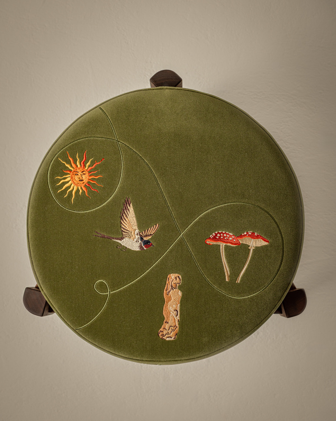 Round green stool with bespoke machine embroidered motifs - features a sun, a bird, two toadstools and a statue