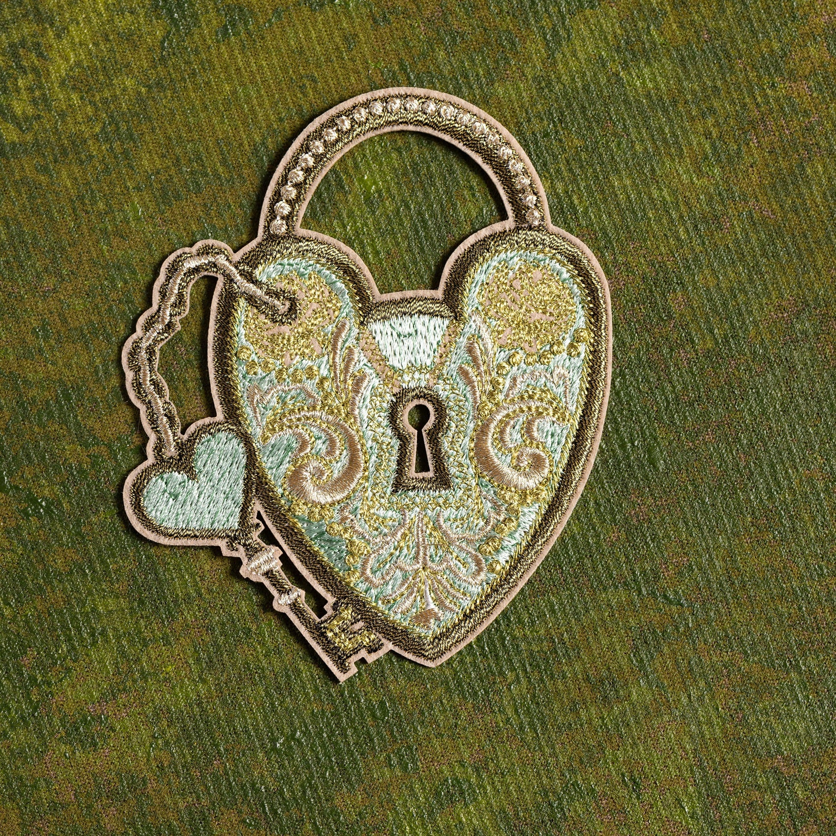 Verdigris Padlock Embroidered Patch - Decorative heart-shaped lock patch with intricate designs on a green background